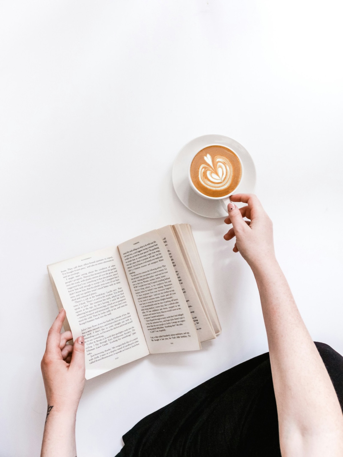 Open book and coffee cup on a white surface — cozy book-study aesthetic