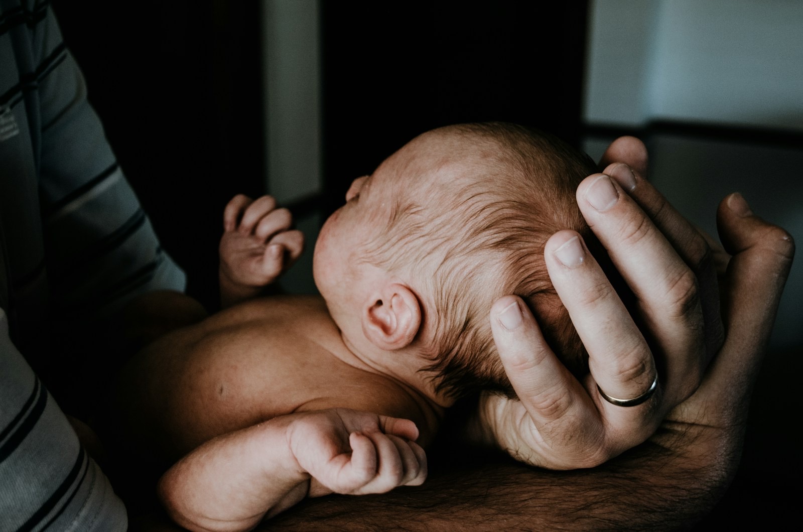 Father cradling a newborn baby in a tender, peaceful moment