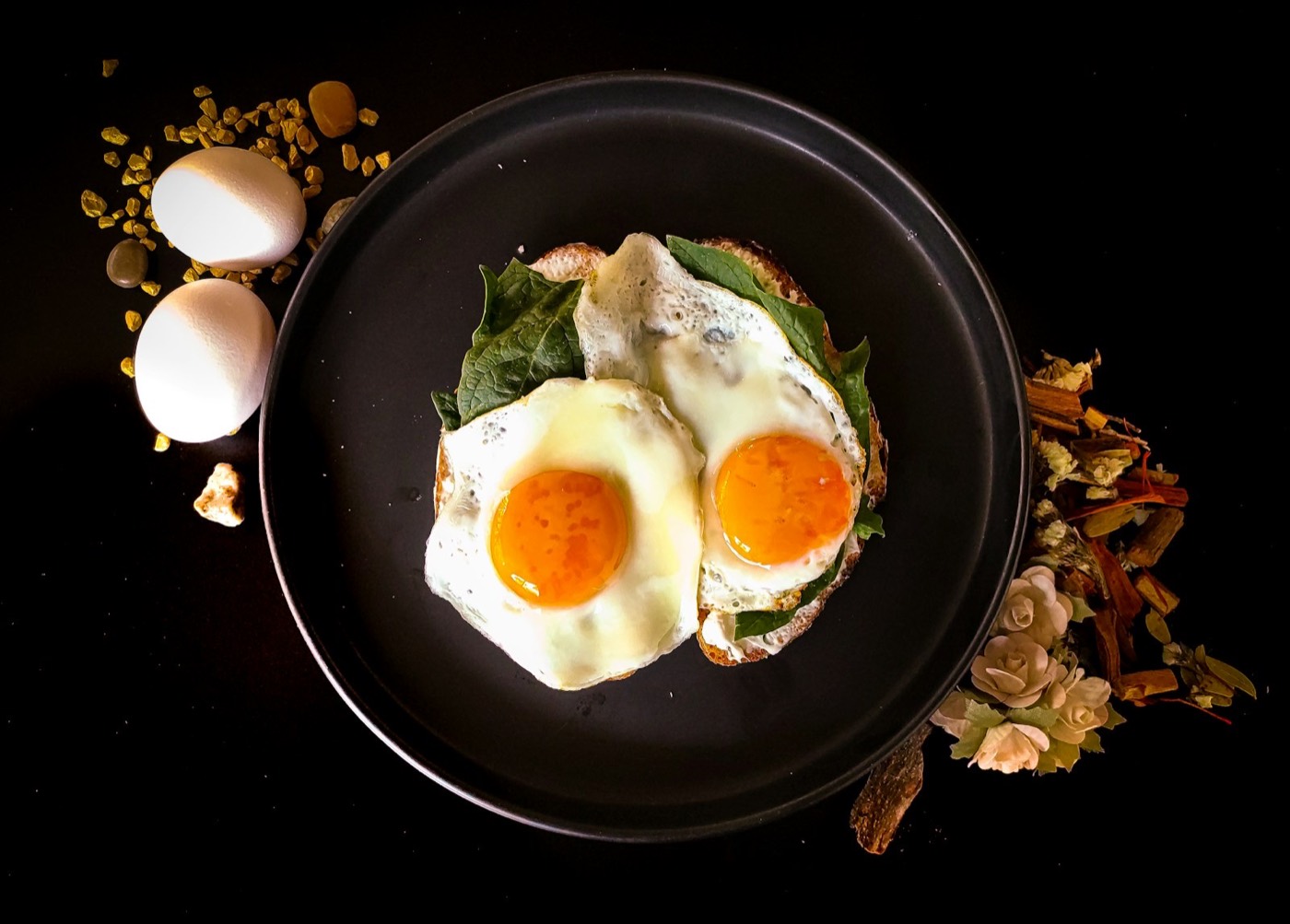 Sunny side up egg on a black ceramic plate, warm breakfast styling
