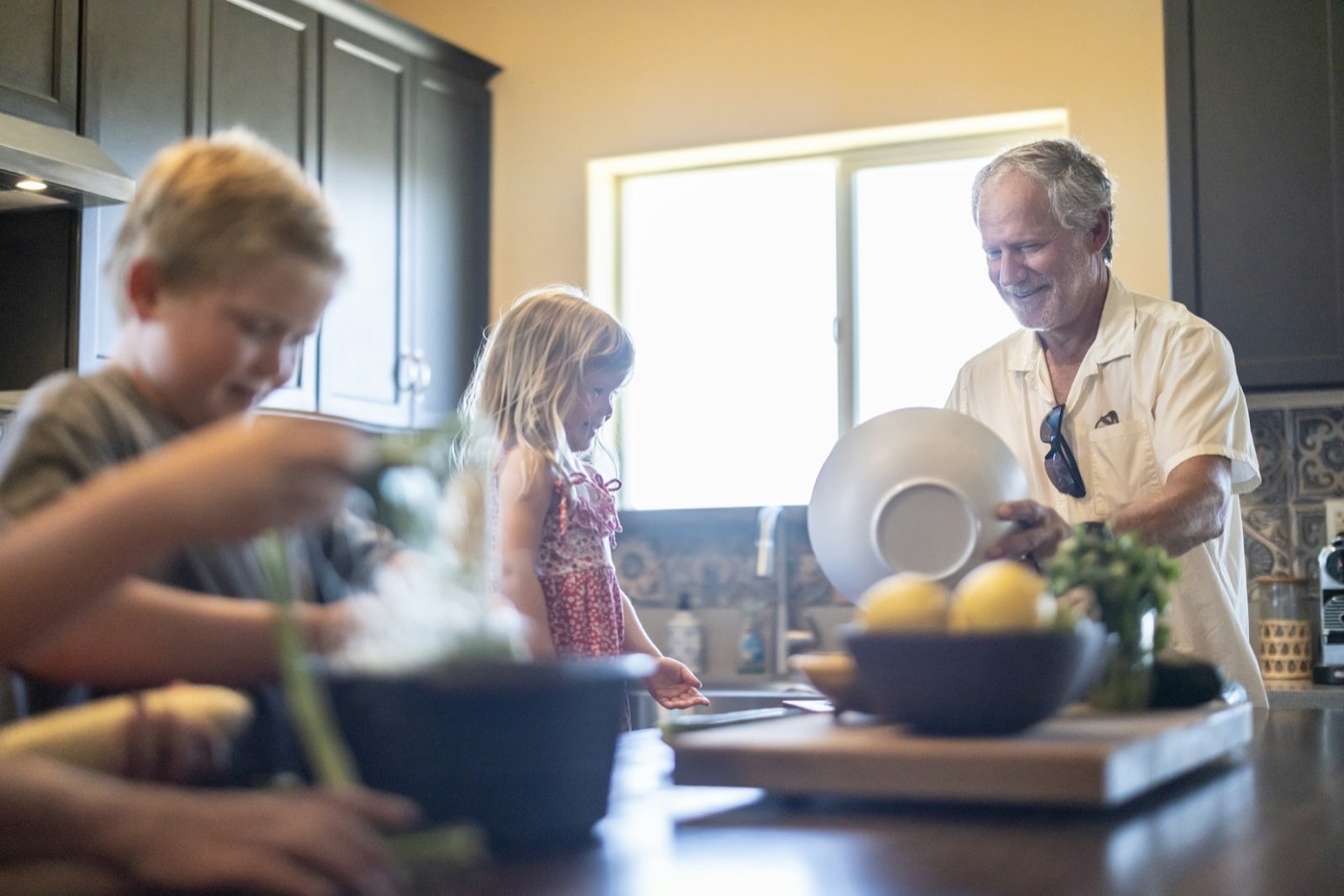Family preparing a fresh salad together in a home kitchen
