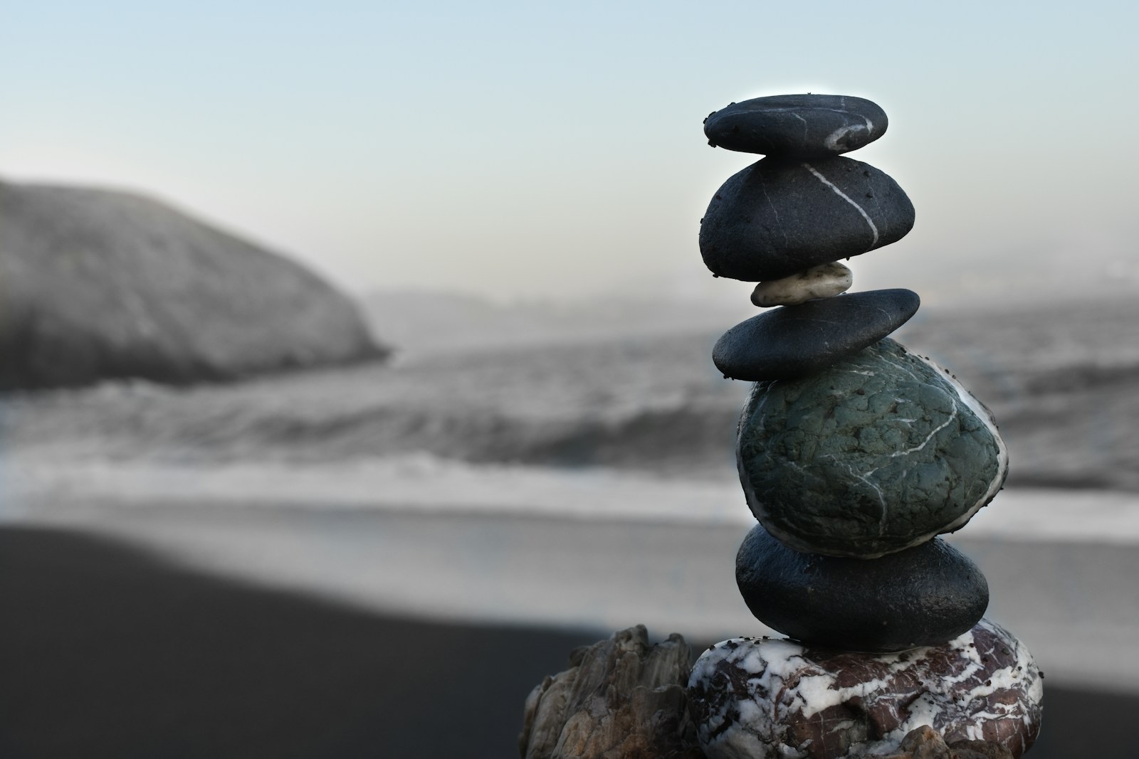 Five black rocks balanced and stacked — visual metaphor for balance